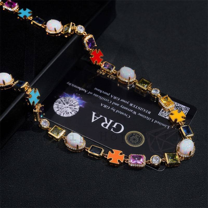 Vibrant gold hip hop jewelry necklace with colorful gemstones on black background.